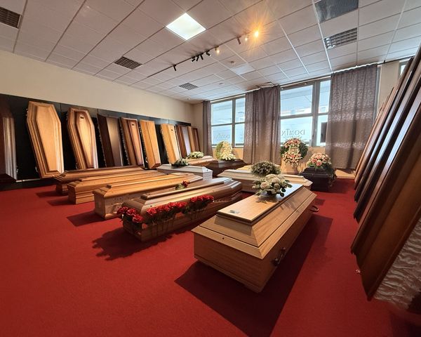 Showroom pohrebnej služby DOMINE v Dunajskej Strede — drevené truhly vystavené v rade